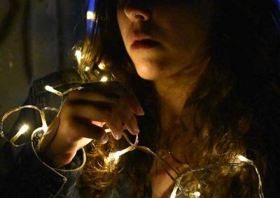 Actriz María Shez foto oscuro iluminada con luces navideñas blanca